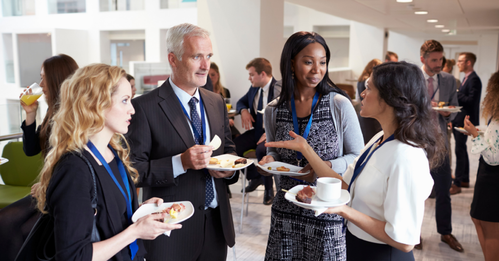 Group of diverse individuals standing and speaking with each other.