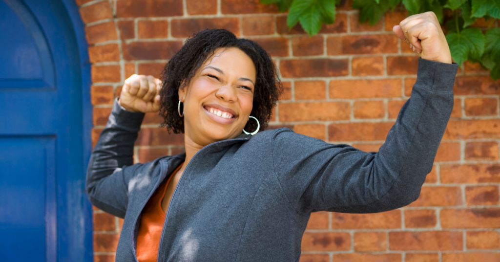 Woman smiling posed with fists in the air.