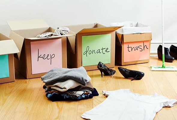 Boxes to declutter labelled "keep", "donate", and "trash" with clothes and shoes on the floor.